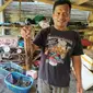 Sobri, salah satu pengusaha lobster asal taman Manalusu, Cikelet, Garut, Jawa Barat, menunjukan lobster ukuran sedang, hasil tangkapan nelayan (Liputan6.com/Jayadi Supriadin)