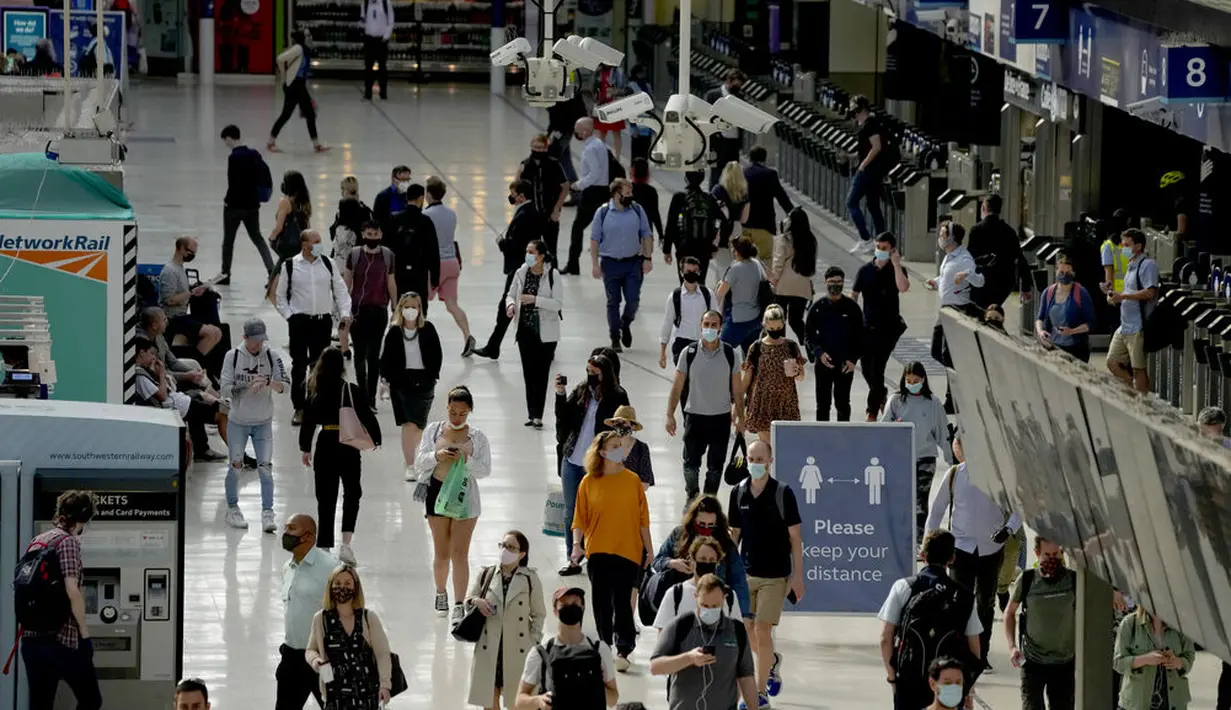 Orang-orang memakai masker setelah turun dari kereta pada jam sibuk pagi hari di stasiun Waterloo di London, Rabu (13/7/2021). Wali Kota Sadiq Khan menekankan transportasi publik di London akan terus memberlakukan kewajiban memakai masker setelah Senin (19/7) mendatang. (AP Photo/Matt Dunham)