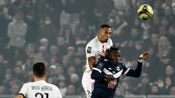 Bek Paris Saint-Germain (PSG) Thilo Kehrer berebut bola melawan penyerang Bordeaux Alberth Elis pada matchday ke-13 Liga Prancis 2021/2022 di Stadion Matmut Atlantique, Minggu (7/11/2021) dini hari WIB. PSG menang tipis 3-2, dengan dua gol disumbangkan Neymar. (Philippe LOPEZ/AFP)