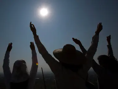 Sejumlah warga mengangkat tangan selama upacara menyambut fenomena equinox di depan Piramida Matahari, Teotihuacan, Meksiko, Senin (20/3). Fenomena equinox merupakan peristiwa ketika matahari tepat berada di atas khatulistiwa. (AP/Rebecca Blackwell)