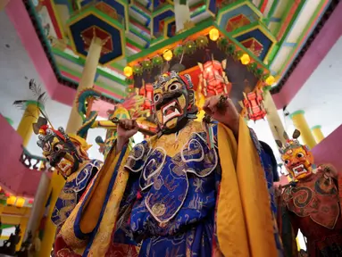 Para biksu yang mengenakan kostum dan topeng yang megah melakukan parade di kuil sebelum Thangka atau lukisan tradisional Buddha diresmikan di kuil Tibet selama perayaan hari Waisak di Ipoh, Malaysia, Rabu, 22 Mei 2024. (AP Photo/Vincent Thian)