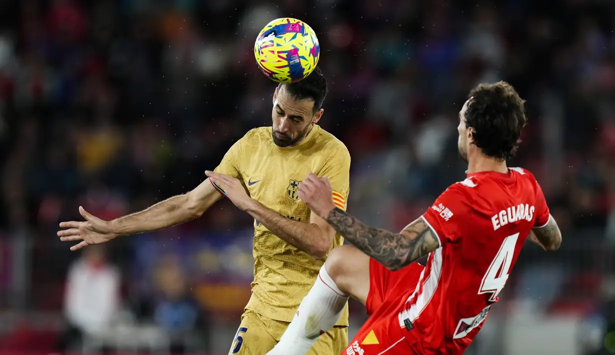 Gelandang Barcelona Sergio Busquets menyundul bola di sebelah gelandang Almeria Inigo Eguaras  pada pekan ke-23 Liga Spanyol di Power Horse Stadium, Senin dini hari WIB (27/2/2023). Meski begitu Barcelona masih berada di puncak klasemen sementara dengan 59 poin. (AP Photo/Jose Breton)