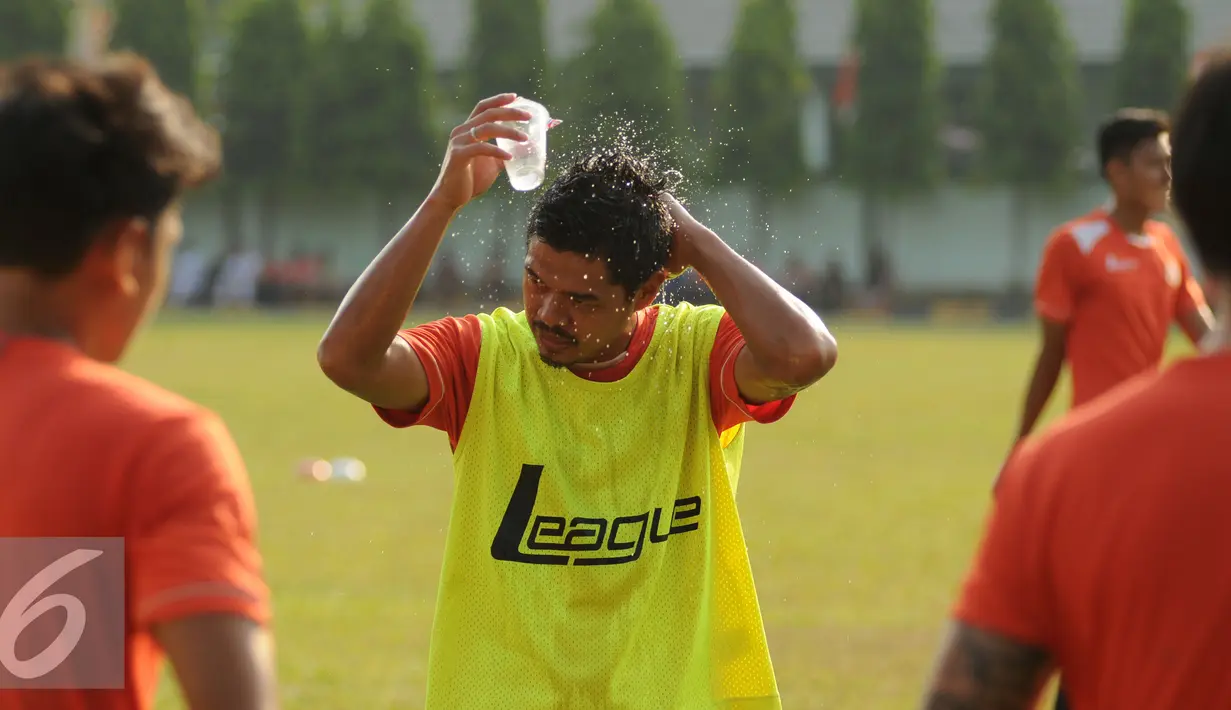Penyerang Persija, Bambang Pamungkas membasahi kepala di sela-sela latihan di Markas Yon Zikon 14, Jakarta, Senin (24/8/2015). Persija kembali berlatih untuk menghadapi turnamen Piala Presiden 2015. (Liputan6.com/Helmi Fithriansyah)