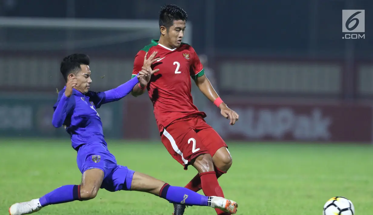 Bek Timnas Indonesia U-23, I Putu Gede Juni Antara berebut bola dengan pemain Thailand U-23 saat uji coba di Stadion PTIK, Jakarta, Kamis (31/5). Babak pertama, Indonesia U-23 ditahan imbang Thailaind U-23. (Liputan6.com/Helmi Fithriansyah)