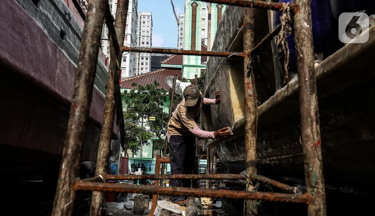 Aktivitas pekerja saat memperbaiki kapal di sebuah galangan kapal kawasan Muara Angke, Jakarta Utara, Kamis (3/6/2021). Butuh 10 hingga 20 pekerja docking kapal untuk memperbaiki satu kapal ikan berjenis 30 GT yang memakan waktu 1 sampai 4 bulan. (Liputan6.com/Johan Tallo)