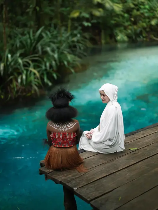 Bak editan, foto Dinda Hauw saat berada di Kali Biru terlihat bernuansa magis. Terlebih saat berfoto dengan wanita asli Papua yang disebutnya Si Manis. (Liputan6.com/IG/@dindahw)