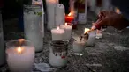 Seorang wanita menyalakan lilin untuk memberikan penghormatan kepada para korban tewas di depan klub malam Jet Set di Santo Domingo, Dominika pada 11 April 2025. (MARTIN BERNETTI/AFP)