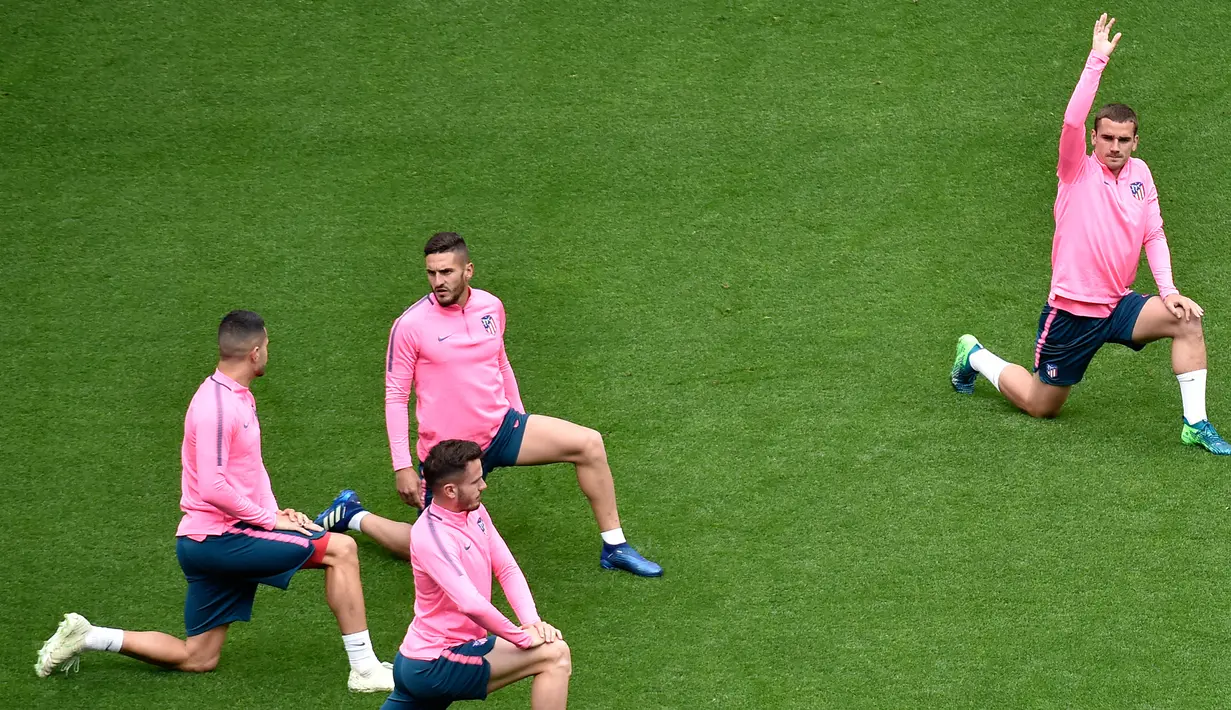 Para pemain Atletico Madrid melakukan pemanasan selama sesi latihan di stadion Parc OL di Decines-Charpieu (15/5). Atletico Madrid akan bertanding melawan wakil Prancis, Marseille pada babak final Liga Europa. (AFP Photo/Jean-Philippe Ksiazek)