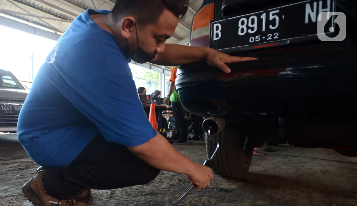 Petugas melakukan uji emisi mobil secara gratis di Bengkel Dinas Lingkungan Hidup DKI Jakarta, Kamis (4/11/2021). Pemprov DKI Jakarta mengumumkan akan menerapkan sanksi tilang bagi kendaraan bermotor yang tidak lulus atau belum melakukan uji emisi. (merdeka.com/Imam Buhori)