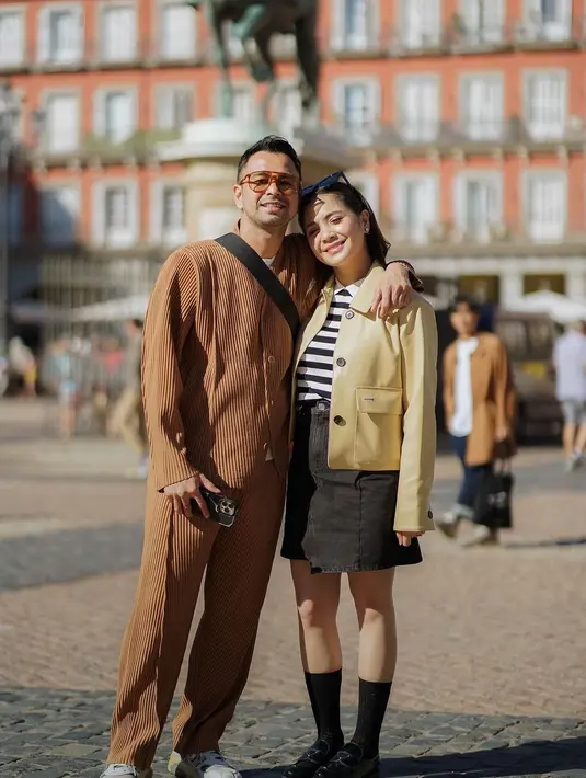 Nagita Slavina memadukan kaus bercorak garis berwarna hitam-putih dengan rok denim berwarna hitam. Ia tumpuk lagi dengan jaket kulit dua kantong berwarna kuning kecokelatan, kaus kaki hitam panjang, dan loafers hitam. [Foto: Instagram/raffinagita1717]