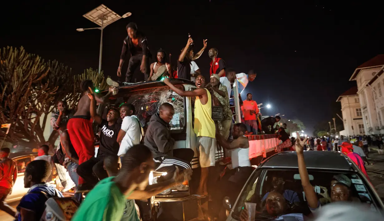 Warga Zimbabwe menari dan bernyanyi menyambut pengunduran diri Presiden Robert Mugabe di sebuah persimpangan pusat kota Harare, Selasa (21/11). Mugabe sebelumnya menolak untuk mengundurkan diri, meski ada pengambilalihan militer pekan lalu (AP/Ben Curtis)