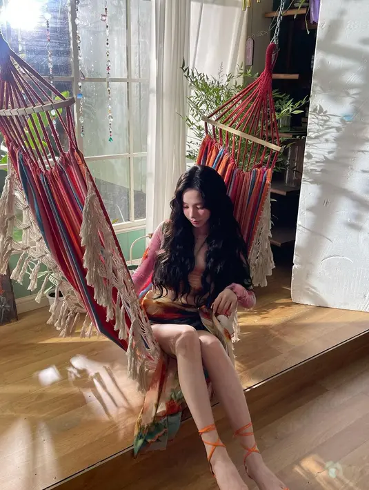 Karina aespa tampil mengenakan outfit bernuansa summer yang super chic. Atasan cropped lengan panjang bercorak flora, dipadukannya kain tie-dye yang bernuansa senada yang cerah. [Foto: Instagram/katarinabluu]