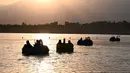 Sejumlah pasukan Taliban menaiki perahu kayuh memutari Danau Qargha di sebuah pekan raya di Kabul barat (28/9/2021). Mereka menikmati waktu luangnya dengan bermain perahu kayuh di danau tersebut. (AFP/Wakil Kohsar)