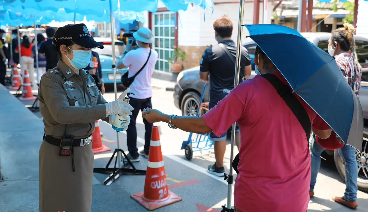 Staf memberikan cairan disinfektan kepada orang-orang di pintu masuk Pasar Akhir Pekan Chatuchak di Bangkok, 9 Mei 2020. Pasar akhir pekan terbesar di Thailand ini kembali dibuka untuk hari pertama pada Sabtu (9/5) dengan sejumlah langkah ketat demi mengatasi pandemi COVID-19. (Xinhua/Zhang Keren)