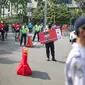 Petugas Dishub dan Satpol PP DKI Jakarta mensosialisasikan protokol kesehatan 3M di kawasan Bundaran HI, Jakarta Pusat, Minggu (8/11/2020). Pemprov DKI Jakarta memastikan masa Pembatasan Sosial Berskala Besar transisi yang berakhir pada hari ini kembali diperpanjang. (Liputan6.com/Faizal Fanani)