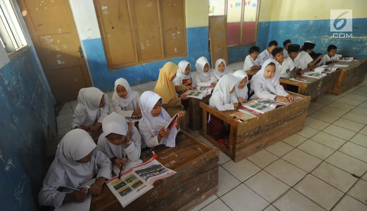 Murid-murid kelas V melakukan kegiatan belajar pada meja yang diubah menjadi kursi dan tempat belajar di SDN Kertajaya 2, Rumpin, Bogor (22/7/2019). Sudah lebih dari tiga tahun mereka belajar  pada fasilitas yang minim. (merdeka.com/Arie Basuki)