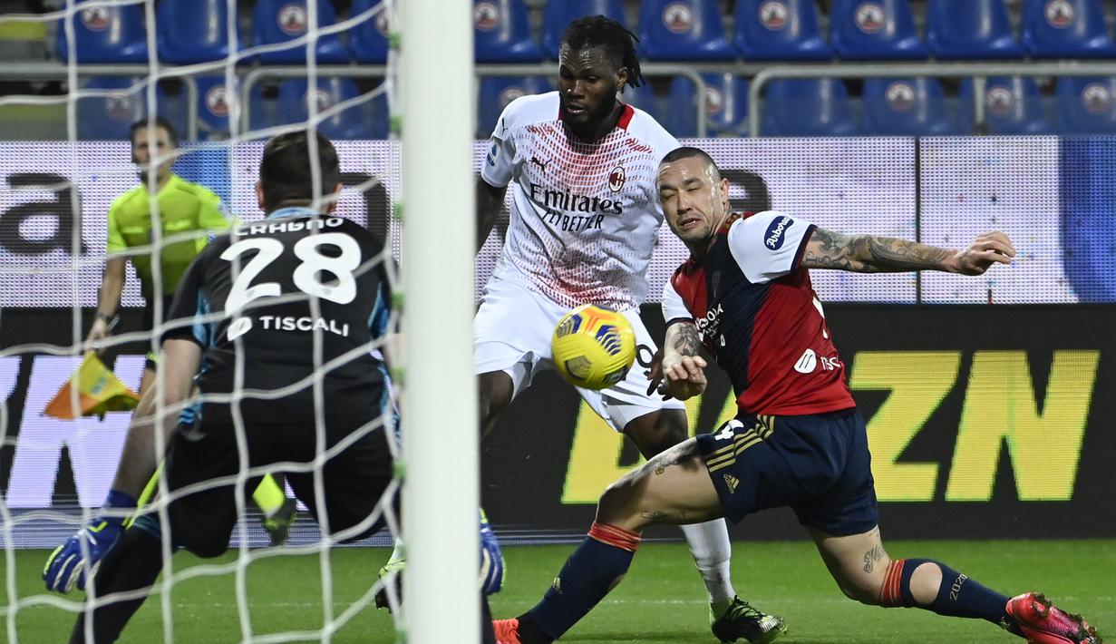 Gelandang AC Milan, Franck Kessie (tengah) melepaskan tendangan dibayangi gelandang Cagliari, Radja Nainggolan dalam laga lanjutan Liga Italia 2020/21 pekan ke-18 di Sardegna Arena, Senin (18/1/2021). AC Milan menang 2-0 atas Cagliari. (AFP/Alberto Pizzoli)