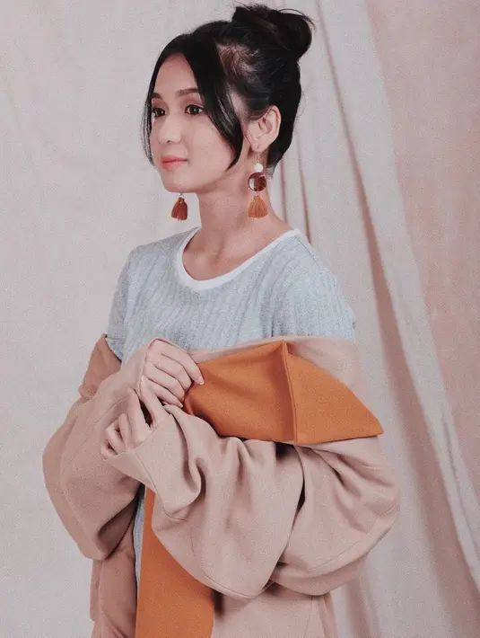 Biasa tampil dengan rambut diurai, ternyata Dea Annisa tetap cantik saat rambutnya dikucir tinggi. Selain itu, aksen poni tipis di tiap sisi kepala juga membuat Dea Annisa semakin memesona, didukung dengan aksesori anting-anting dan busana bernuansa cokelat. (Liputan6.com/IG/@deaaannisa)