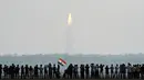 Warga India melihat peluncuran 104 satelit dalam satu misi di pusat antariksa Sriharikota di India timur, Rabu (15/2). Keberhasilan ini membuat India menciptakan rekor dunia dalam peluncuran satelit. (AFP PHOTO/ ARUN SANKAR) 