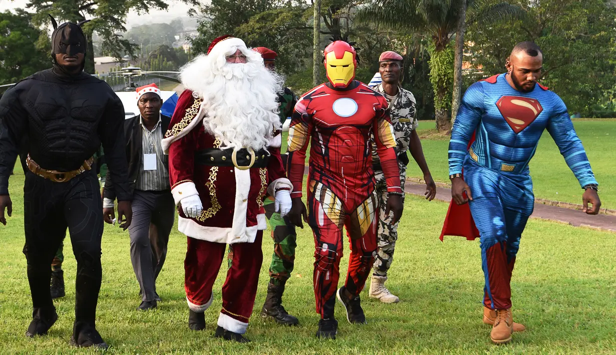 Sejumlah pria mengenakan kostum pahlawan super berjalan di istana kepresidenan di Pantai Gading (23/12). Mereka mengenakan kostum tokoh pahlawan super seperti Batman, Santa Claus, Iron Man dan Superman. (AFP Photo/Sia Kambou)