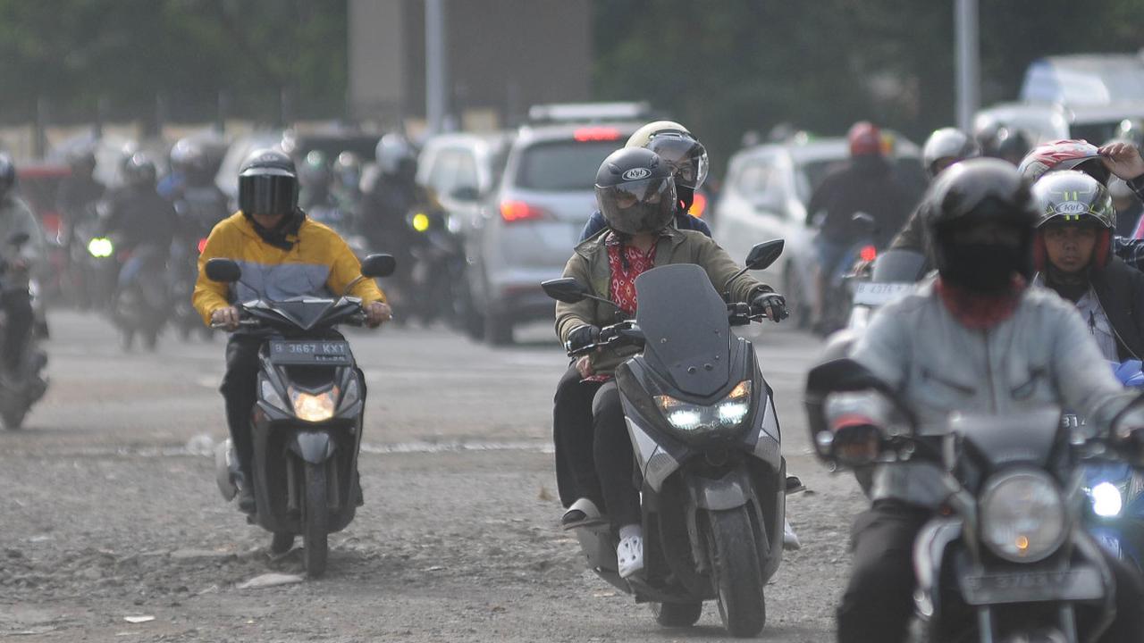 Pengendara bermotor saling berebut jalan saat melintasi Jalan Raya Kalimalang yang padat merayap di Jakarta, Kamis (11/1/2023).