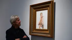 Seorang kurator galeri mengamati lukisan kandidat Presiden AS dari Partai Republik, Donald Trump dalam keadaan telanjang, di Galeri Maddox, London, Sabtu (9/4). Lukisan karya Illma Gore itu diberi judul “Make America Great Again” (Niklas HALLE'N/AFP)