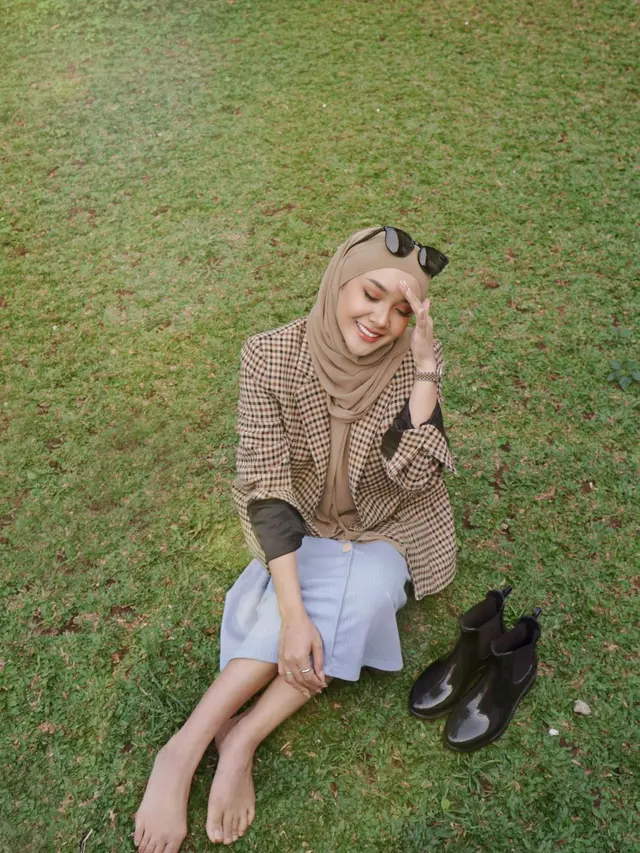 Mengenakan hijab cokelat, Cita Citata menikmati suasana di luar rumah. Duduk di rerumputan membuatnya bahagia. (Foto: Instagram/@cita_citata)