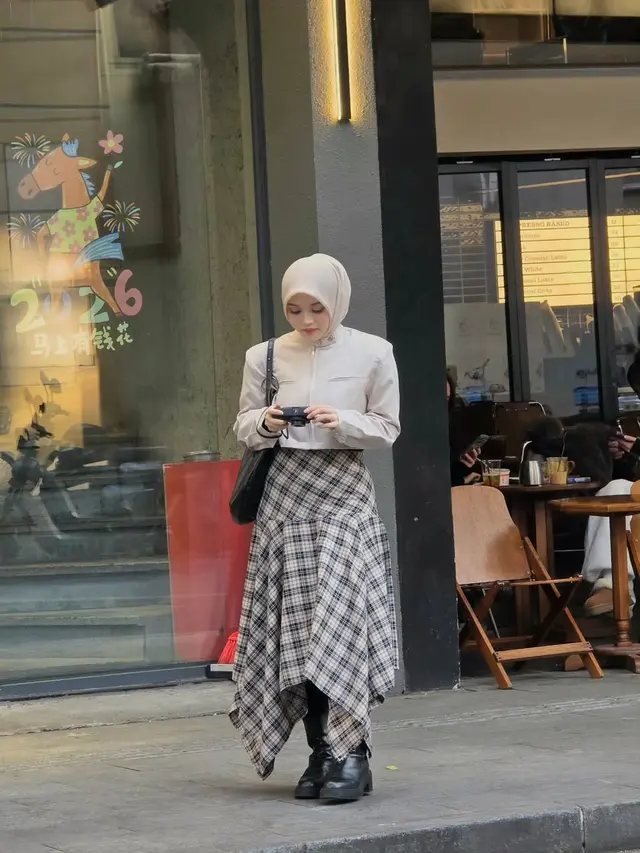 Gaya Modest Preppy Delina Putri Liburan di China dengan Rok Tartan dan Cropped Jacket