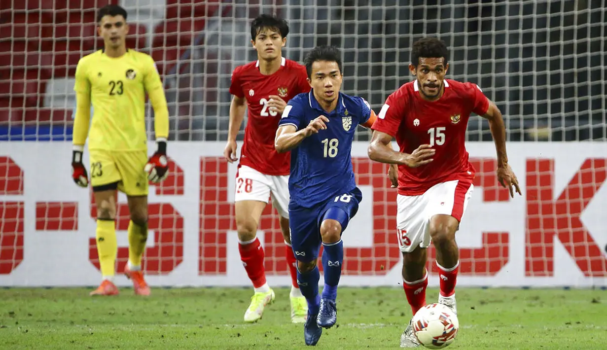 Pemain Indonesia Ricky Richardo Kambuaya (kanan) bersaing memperebutkan bola dengan pemain Thailand Chanathip Songkrasin pada pertandingan sepak bola leg kedua final Piala AFF 2020 di National Stadium, Singapura, Sabtu (1/1/2022). Pertandingan berakhir dengan skor 2-2.  (AP Photo/Suhaimi Abdullah)