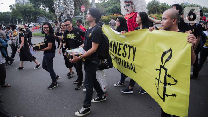 Aktivis yang tergabung dalam Amnesty Internasional Indonesia menggelar aksi di depan Istana Negara, Jakarta, Selasa (10/12/2019). Dalam aksi tersebut aktivis memberikan bingkisan kepada Sekretariat Kabinet yang berisi aspirasi masyarakat Indonesia untuk pemerintah. (Liputan6.com/Faizal Fanani)