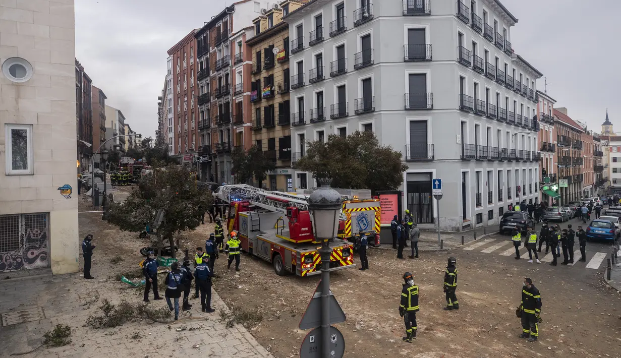 Petugas pemadam kebakaran dan polisi bekerja di lokasi ledakan di pusat kota Madrid, Spanyol, Rabu (20/1/2021). Ledakan keras telah menghancurkan sebagian bangunan kecil yang diapit oleh sekolah dan panti jompo di pusat ibu kota Spanyol. (AP Photo/Manu Fernandez)