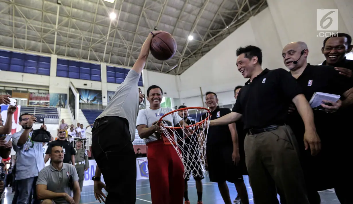 Wakil Gubernur DKI Jakarta Sandiaga Uno memasukkan bola basket ke dalam jaring sebagai simbol dibukanya pelatihan pendidikan basket di GOR Ciracas, Jakarta, Rabu (24/1). (Liputan6.com/Faizal Fanani)