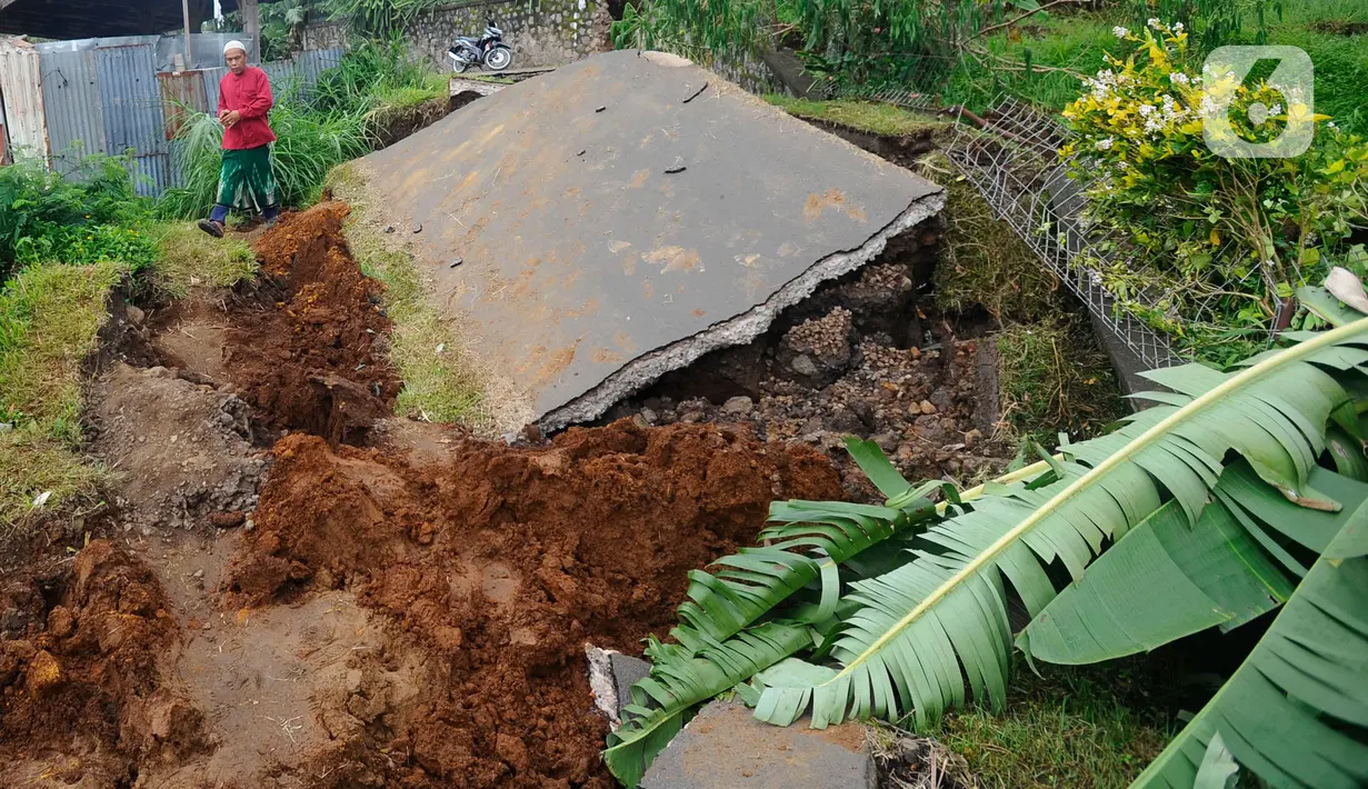 Warga melintas di jalan yang rusak  pascagempa bumi magnitudo 5,6 di Kampung Cisarua, Desa Sarampad, Kabupaten Cianjur, Jawa Barat, Rabu (23/11/2022). Gempa di Kabupaten Cianjur, Jawa Barat, mengakibatkan sejumlah rumah dan jalan rusak parah di Desa Sarampad. (merdeka.com/Arie Basuki)