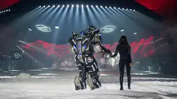 Model Irina Shayk melenggang ditemani robot sambil membawakan koleksi desainer Philipp Plein dalam New York Fashion Week 2018, Sabtu (10/2). Robot warna hitam yang bentuknya menyerupai Transformers itu lalu berjalan di sepanjang catwalk  (AP/Craig Ruttle)