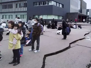 Retakan terlihat pada tanah usai gempa bumi di Wajima, Prefektur Ishikawa, Jepang, Senin (1/1/2024). Jepang mengeluarkan peringatan tsunami setelah serangkaian gempa kuat di Laut Jepang. (Kyodo News via AP)