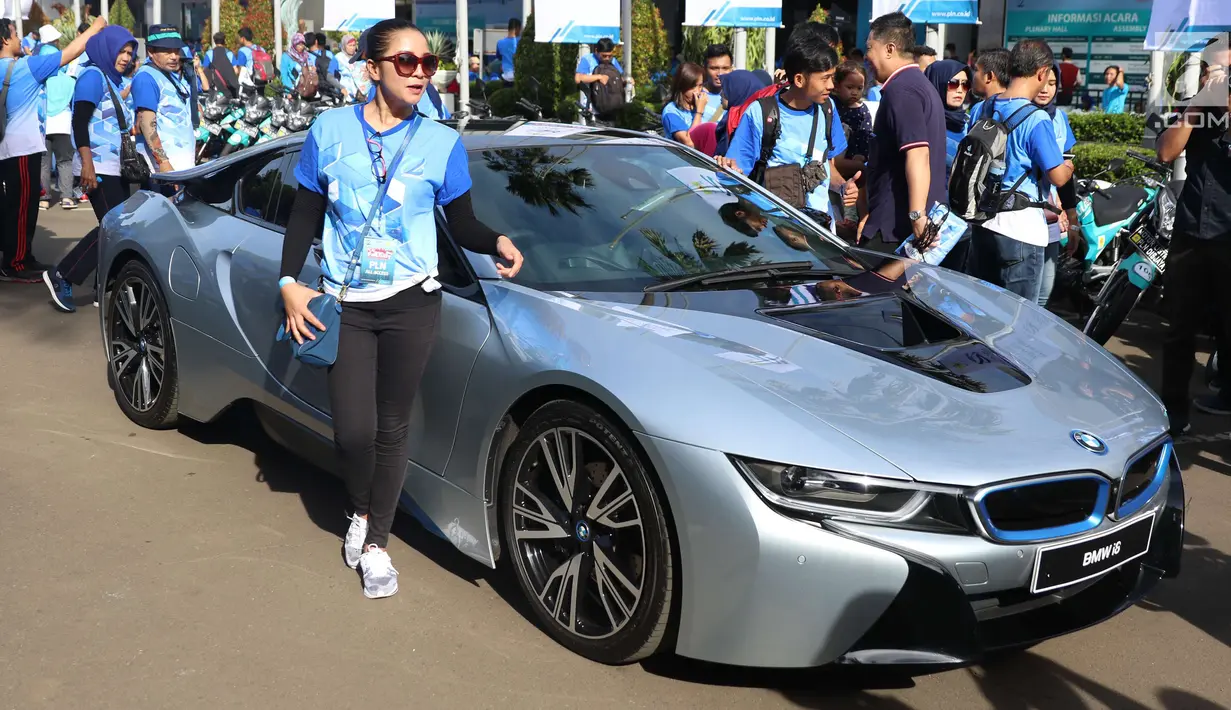 Seorang wanita berdiri disamping mobil listrik yang dipajang di Kawasan JCC di Jakarta, Minggu (3/12). PLN (Persero) menggelar pameran ratusan inovasi teknologi di sektor kelistrikan. (Liputan6.com/Angga Yuniar)