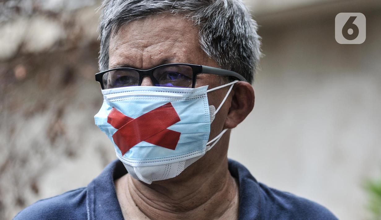 Rocky Gerung mengenakan masker dengan tanda silang (x) saat hadir mendampingi pemeriksaan Direktur Lokataru Haris Azhar di Polda Metro Jaya, Jakarta, Senin (21/3/2022). Haris Azhar diperiksa dalam kasus dugaan fitnah dan pencemaran nama baik Luhut Binsar Pandjaitan. (merdeka.com/Iqbal S. Nugroho)