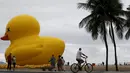 Warga beraktivitas di sekitar balon raksasa berbentuk bebek di pantai Copacabana, Brasil, Minggu (25/10). Kampanye "I will not pay the Duck" ini mengacu pada industri yang membayar pajak tinggi. (REUTERS/Sergio Moraes)