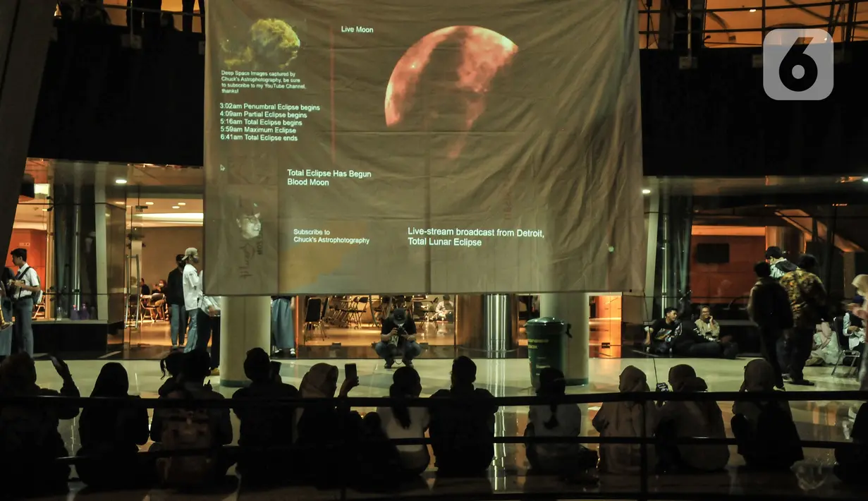 Warga menyaksikan fenomena gerhana bulan total atau Bloodmoon di Taman Ismail Marzuki, Jakarta Pusat, Selasa (8/11/2022). Warga tetap antusias mendatangi Taman Ismail Marzuki untuk menyaksikan fenomena Gerhana Bulan Total yang digelar oleh Planetarium dan Obersevasi Jakarta (POJ) meski turun hujan dan hanya melihat dari siaran langsung (streaming). (merdeka.com/Iqbal S Nugroho)