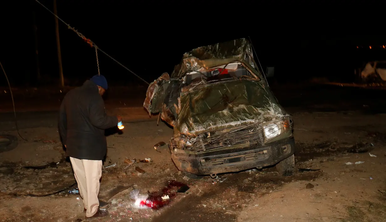 Warga melihat puing-puing di sekitar tempat terjadinya kecelakaan mobil di Kenya, Minggu (11/12). Belasan mobil terbakar dan sekitar 30 orang tewas. (REUTERS / Stringer)