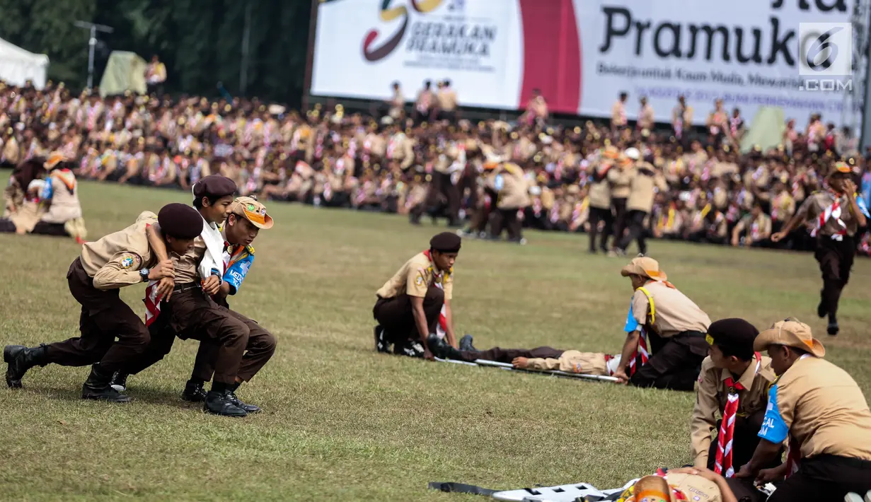 Sejumlah peserta beraksi dalam acara pembukaan Raimuna Nasional XI yang digelar di Bumi Perkemahan Cibubur, Jakarta Timur, Senin (14/8). Acara itu digelar bersamaan dengan acara Hari Pramuka ke-56. (Liputan6.com/Faizal Fanani)