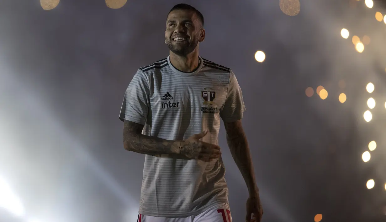 Bek Dani Alves tersenyum saat diperkenalkan sebagai bek baru Sao Paulo di stadion Morumbi, Brasil (6/8/2019). Dani Alves akan memakai kostum dengan nomor punggung 10 di Sao Paulo. (AP Photo/Andre Penner)