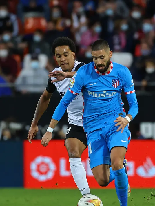 Gelandang  Valencia, Helder Costa (kiri) berusaha merebut bola dari gelandang Atletico Madrid, Yannick Ferreira-Carrasco selama pertandingan lanjutan La Liga Spanyol di stadion Mestalla di Valencia (8/11/2021). Valencia bermain imbang atas Atletico Madrid 3-3. (AFP/Jose Jordan)