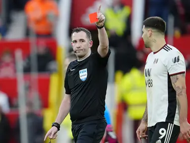 Pemain Fulham, Aleksandar Mitrovic (kanan), menatap wasit Chris Kavanagh yang memberikan kartu merah kepada Willian yang menghalau bola menggunakan tangannya untuk mencegah gawang timnya kebobolan dalam babak perempat final Piala FA 2022/2023 melawan Manchester United yang berlangsung di Old Trafford, Minggu (19/3/2023) malam WIB. (AP Photo/Jon Super)