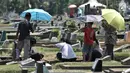 Kelompok anak-anak menawarkan jasa membersihkan makam di TPU Penggilingan, Pulogadung, Jakarta, Kamis (10/5). Tradisi ziarah jelang Ramadan menjadi berkah bagi anak-anak pembersih makam atau biasa dikenal 'Ngoret'. (Merdeka.com/Iqbal S. Nugroho)