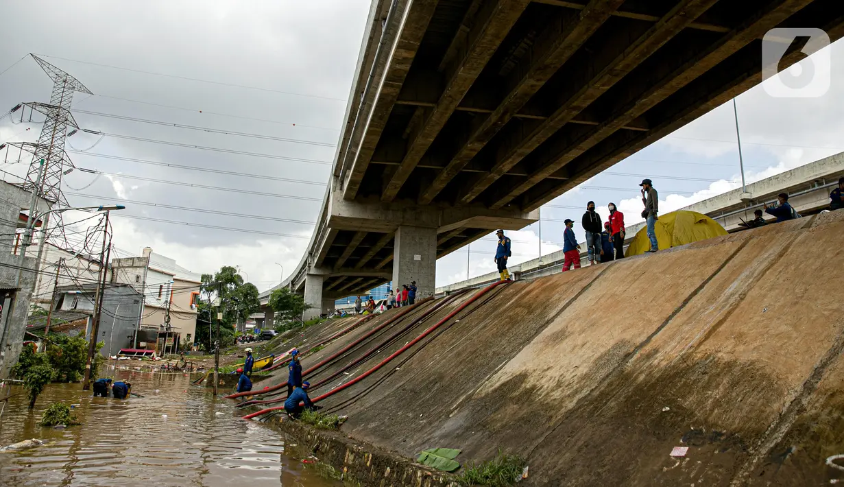 Petugas pemadan kebakaran menyedot air banjir di kawasan Cipinang Melayu, Jakarta, Minggu (21/2/2021). Suku Dinas Pemadam Kebakaran Jakarta Timur mengerahkan 20 mobil pompa untuk menyedot air yang membanjiri RW 04 Kelurahan Cipinang Melayu untuk mengurangi debit air. (Liputan6.com/Faizal Fanani)