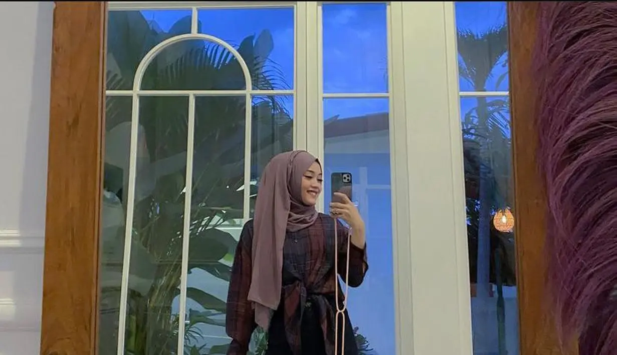 Bisa jadi inspirasi para hijabers, coba ikat plaid shirt seperti gaya Putri Delina ini, makin stylish! High waist yang dikenakannya membuat penampilannya semakin terlihat jenjang.  (Instagram/putridelinaa).