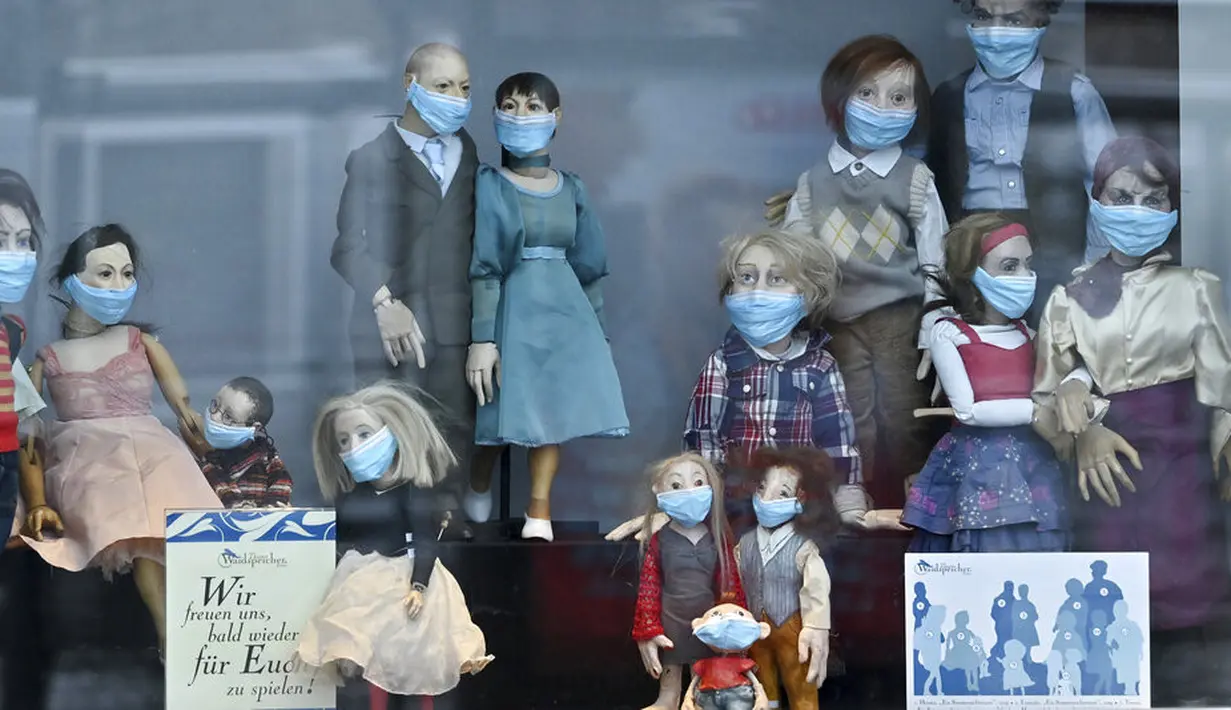 Tokoh teater boneka memakai masker di etalase teater Waidspeicher, Erfurt, Jerman, Selasa (5/1/2021). Pembatasan ketat tengah diberlakukan saat ini dengan menutup toko, sekolah, dan jasa layanan di seluruh Jerman sejak 16 Desember 2020. (Martin Schutt/dpa via AP)