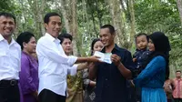 Presiden Jokowi menyerahkan secara simbolis Kartu Indonesia Sehat kepada pekerja PTPN III di Deli Serdang, Sumatera Utara, Sabtu (18/4/2015). (Setkab.go.id)