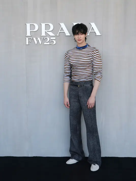 Byeon Woo-seok tampil playful memadukan striped long sleeve top, wide leg jeans, dan sepatu putih, [Dok/Prada]